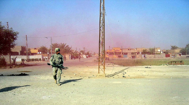 Image of a solider walking through colored smoke