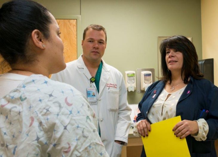 Image: VA medcial staff talk with a female Veteran.
