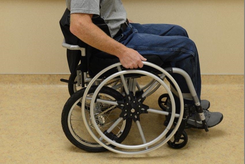 A wheelchair with a man sitting in it.