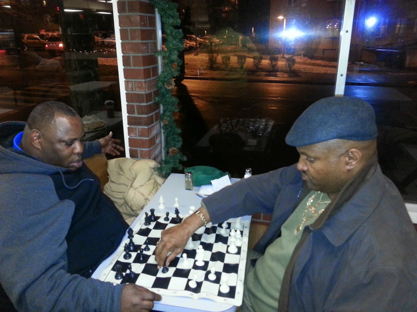 Two men play chess inside.