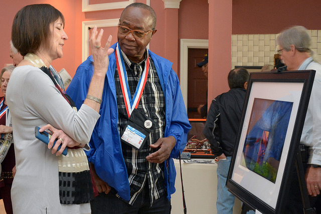 A Veteran discusses his artwork on display at the National Veterans Creative Arts Festival.