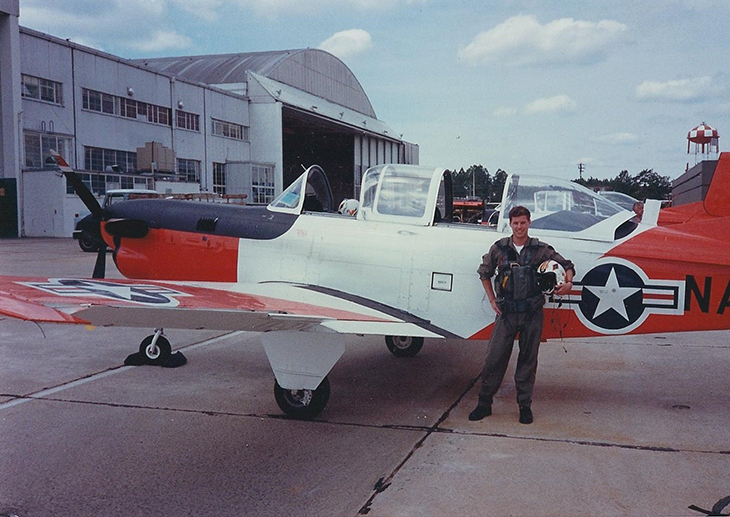 Sam Gordy pictured with an air plane in his Navy days when he was serving as a as Lieutenant JG.