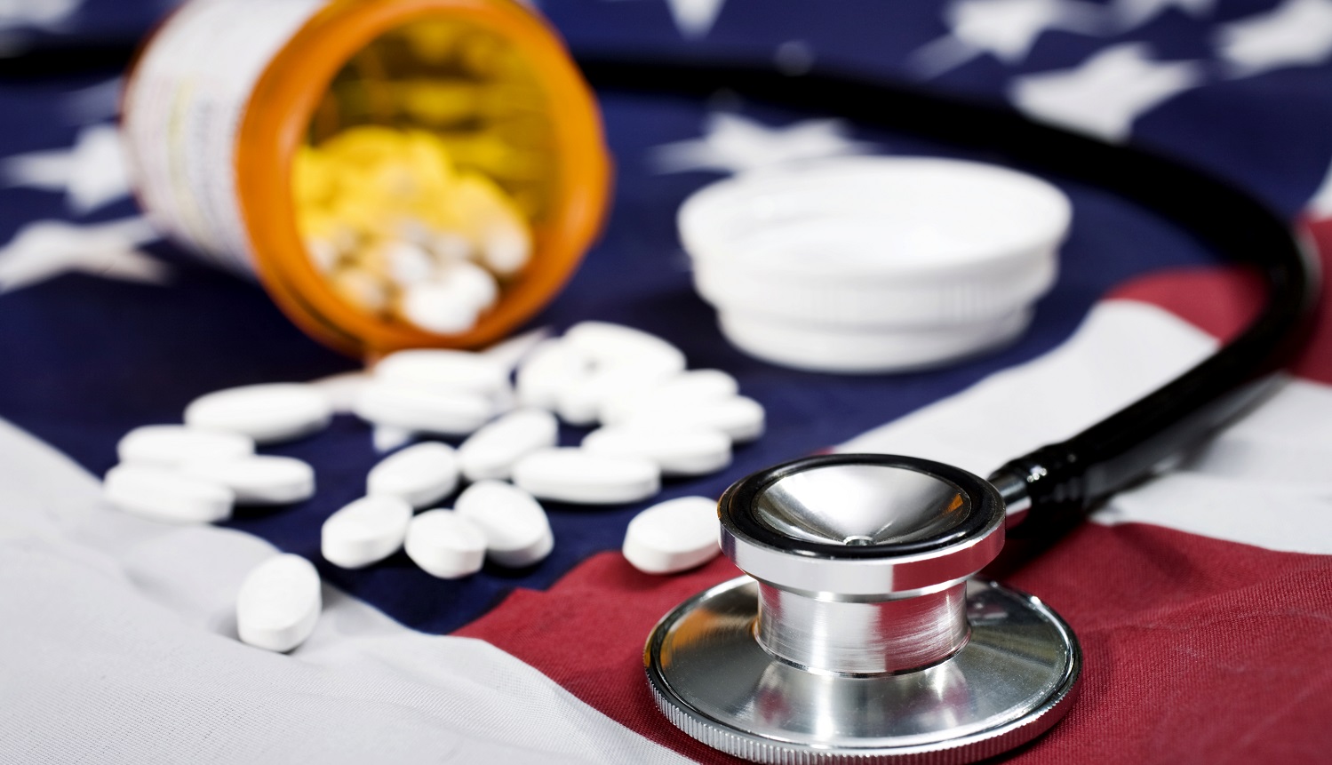 Pills and a stehoscope on an American Flag