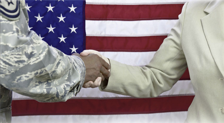 Image of military and civilian shaking hands in front of Old Glory.