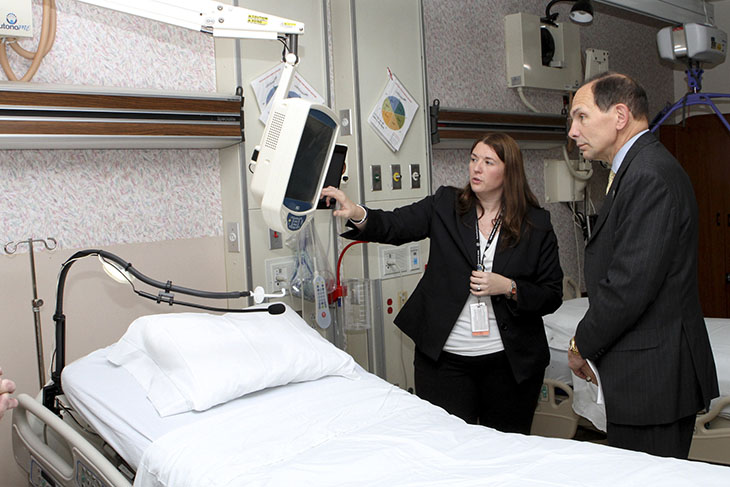 Image ofBob McDonald observing assistive technology in a hospital room.