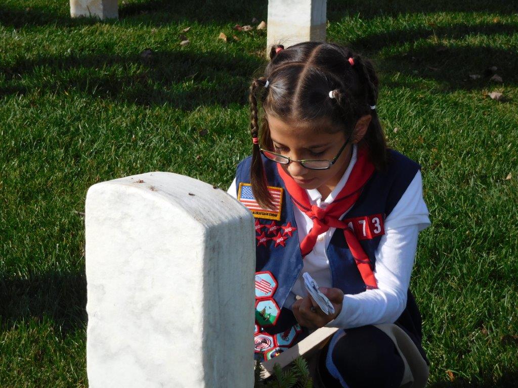 girl scout kneeling before a grave marker at Richmond National Cemetery, veterans legacy