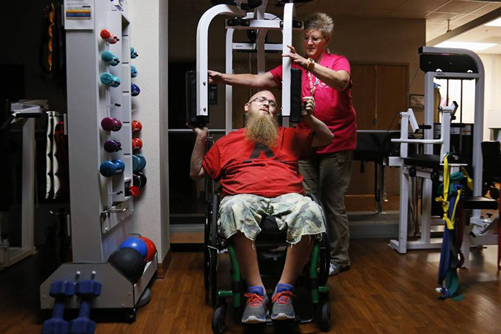 Tammy Beeler, a registered Kinesiotherapist, assists Emmet Pryor at the Dallas VA Medical Center Spinal Cord Injury Center train for the National Veterans Wheelchair Games.