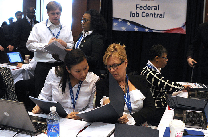 Image of two women engaged in a conversation at a both during a career fair.