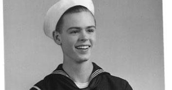 George DeLong in sailor uniform with arm's crossed