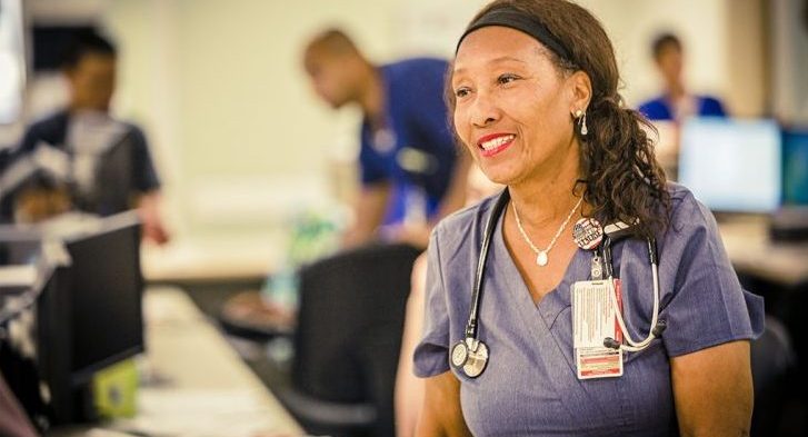 VA Nurse manages her nursing station and helps a community member