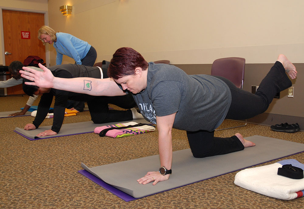 Veterans in the yoga study group work on perfecting a pose under the gentle guidance of Lead Yoga Therapist Nancy Schalk.