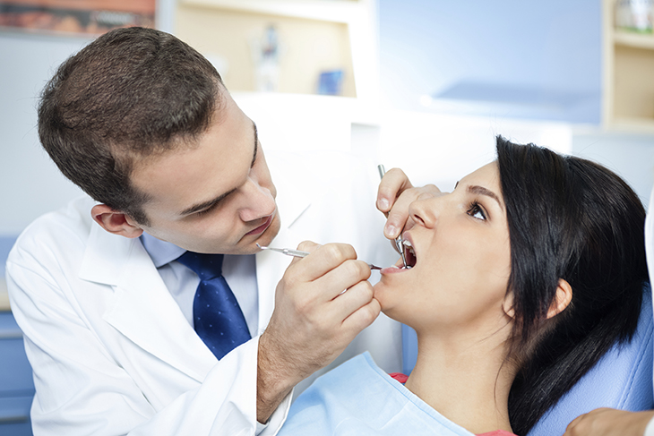 Image of a dentist examining a patient's teeth