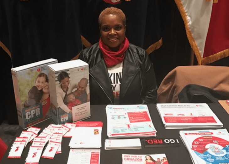 image of a VA employee displaying healthy heart information during a VA Goes Red for Women event.