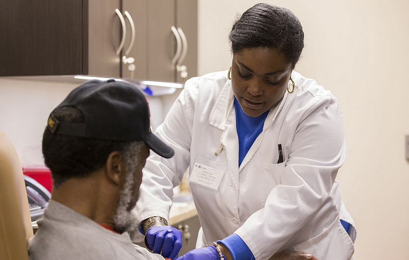 Image of a VHA medical staff member drawing blood from a Veteran in a clinical setting.