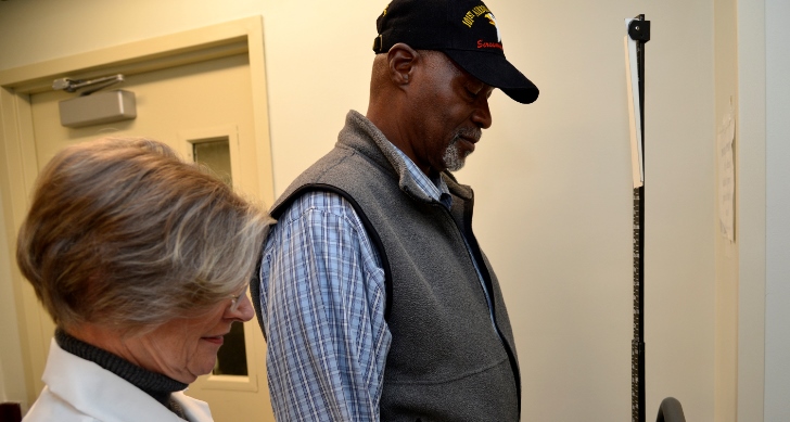 Image of Veteran Razzi Odom checks the scale while Becci Luhrs, MOVE! program coordinator, notes his progress toward his goal of dropping 31 pounds. Photo by James Arrowood.