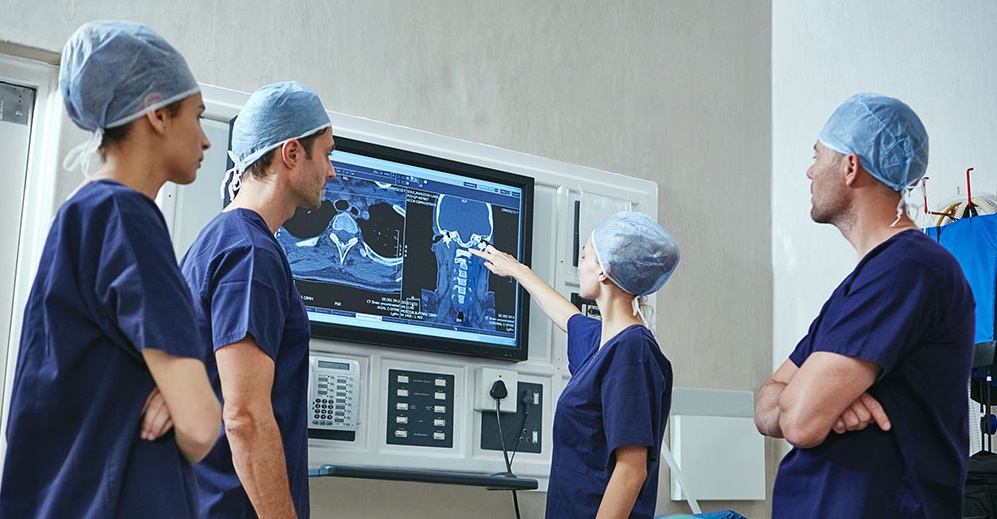 Surgeons reviewing x-ray of patient
