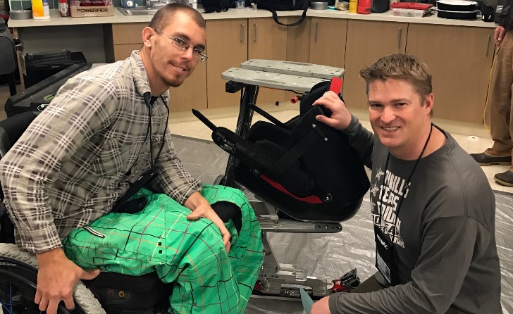 Image: John Ashbaugh gets fitted for his adaptive sports equipment with assistance from Chad Kincaid, a physical therapist and prosthetist helping at the seating/technology/boot fit clinic.