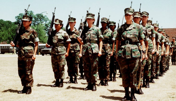 The Marine Corps' first all-woman drill platoon stands at attention in formation with M-16A1 rifles. The platoon was commanded by 1st Lt. Marie G. Juliano.