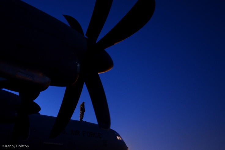 IMAGE: of a service member a top of a C130.