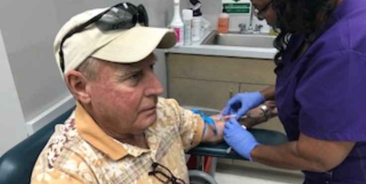 Image: Abbigail Ford draws a blood sample from Veteran Roy of Meridian, Mississippi to test for Hep C.