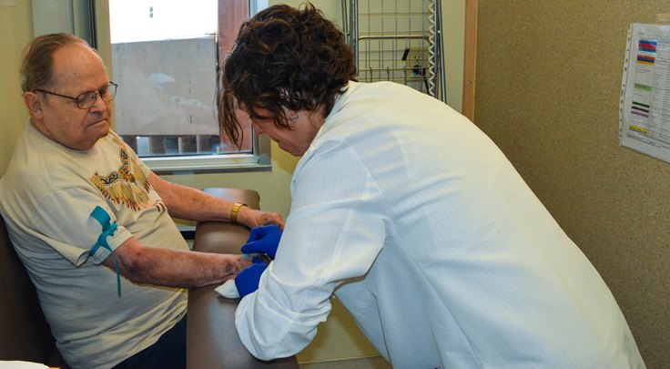 image: Annette Videla, a registered nurse and research coordinator with the Phoenix VA Health Care System’s Million Veteran Program, prepares to extract blood from a volunteer. The Phoenix VA surpassed its goal of recruiting 20,000 volunteers for the nationwide initiative.