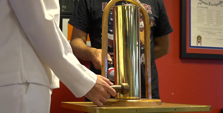 IMAGE: A brass bell, made from a shell casing, is rung in honor of Veterans lost to suicide.