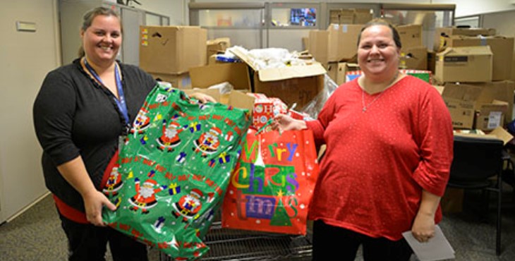 IMAGE: Voluntary Service Specialist Candy Anderson presents Cathy Adkins, spouse of Veteran Thomas Adkins, Sr., with gifts for her children that were donated through Voluntary Service’s Angel Tree program. Photo by Meredith A. Hagen.