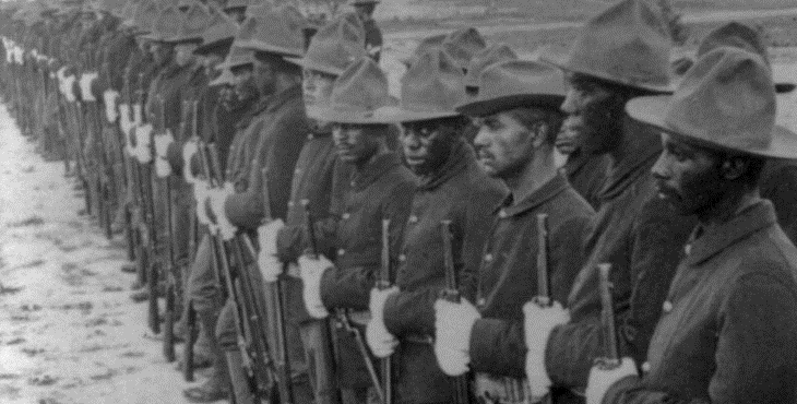 Historic black and white photograph of Buffalo Soldiers standing in formation in Cuba.