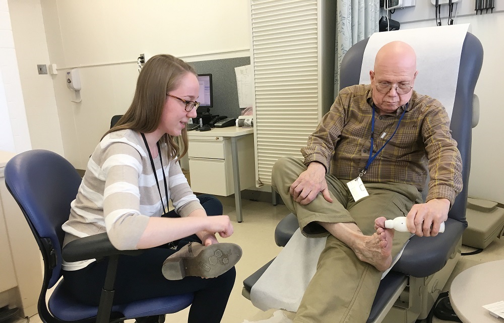 Health science specialist Tova Bergsten watches as Army Reserve Vietnam-era Veteran Stephen Fisher demonstrates a special thermometer being used in STEP UP that can help detect early-stage ulcers. (Photo by Claudie Benjamin)