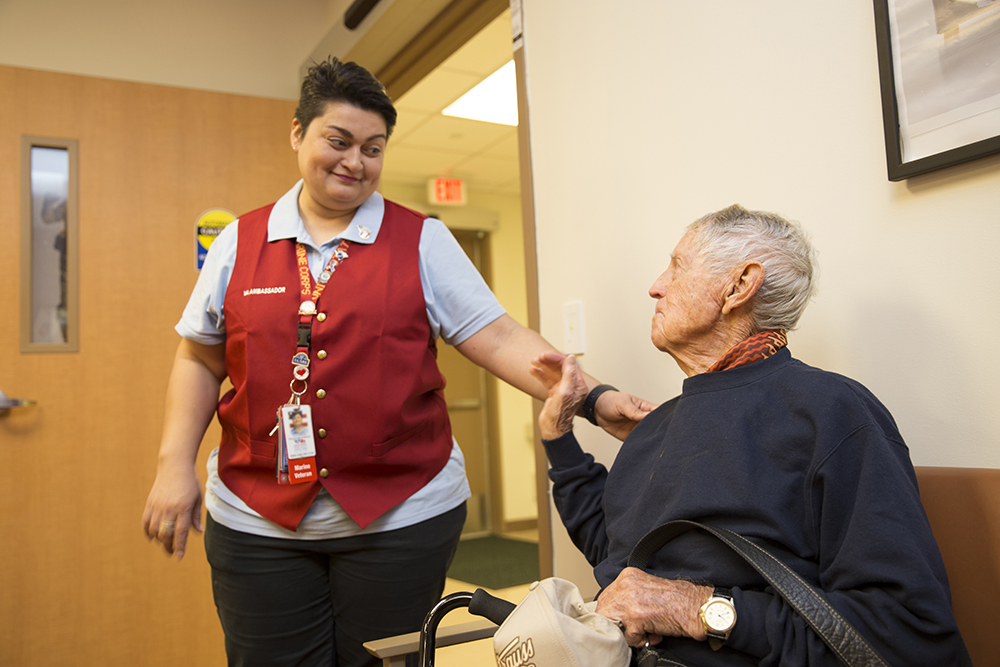 Red Coat Ambassador Lilia Garcia thanks World War II Coast Guard Veteran Jack Kelley about the local VA volunteer opportunities during for his service after escorting him to the prosthetics office located inside the VA Health Care Center at Harlingen, Texas, March 8, 2018. Red Coat Ambassadors help Veterans in many ways, which include escorting them the proper locations for their VA appointments. (U.S. Department of Veterans Affairs photo by Luis H. Loza Gutierrez)