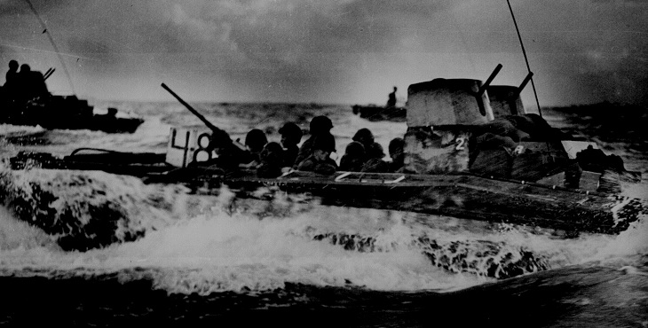 Marines ride on an amphibious vehicle near Guam July 1944. Photograph from the National Archives.