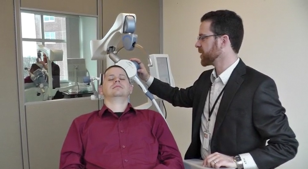 Dr. Noah Philip, Director of Psychiatric Neuromodulation at Providence VA, treats a patient using TMS therapy.