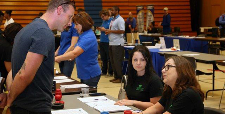 IMAGE: a Veterans talks to staff at a hiring event