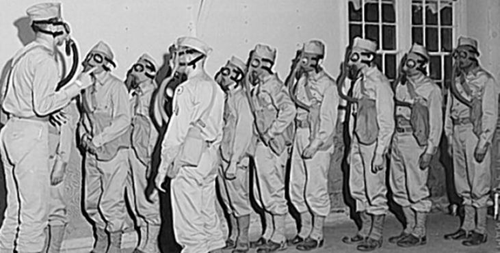 IMAGE: WWII troops in a gas Chamber with protective masks.