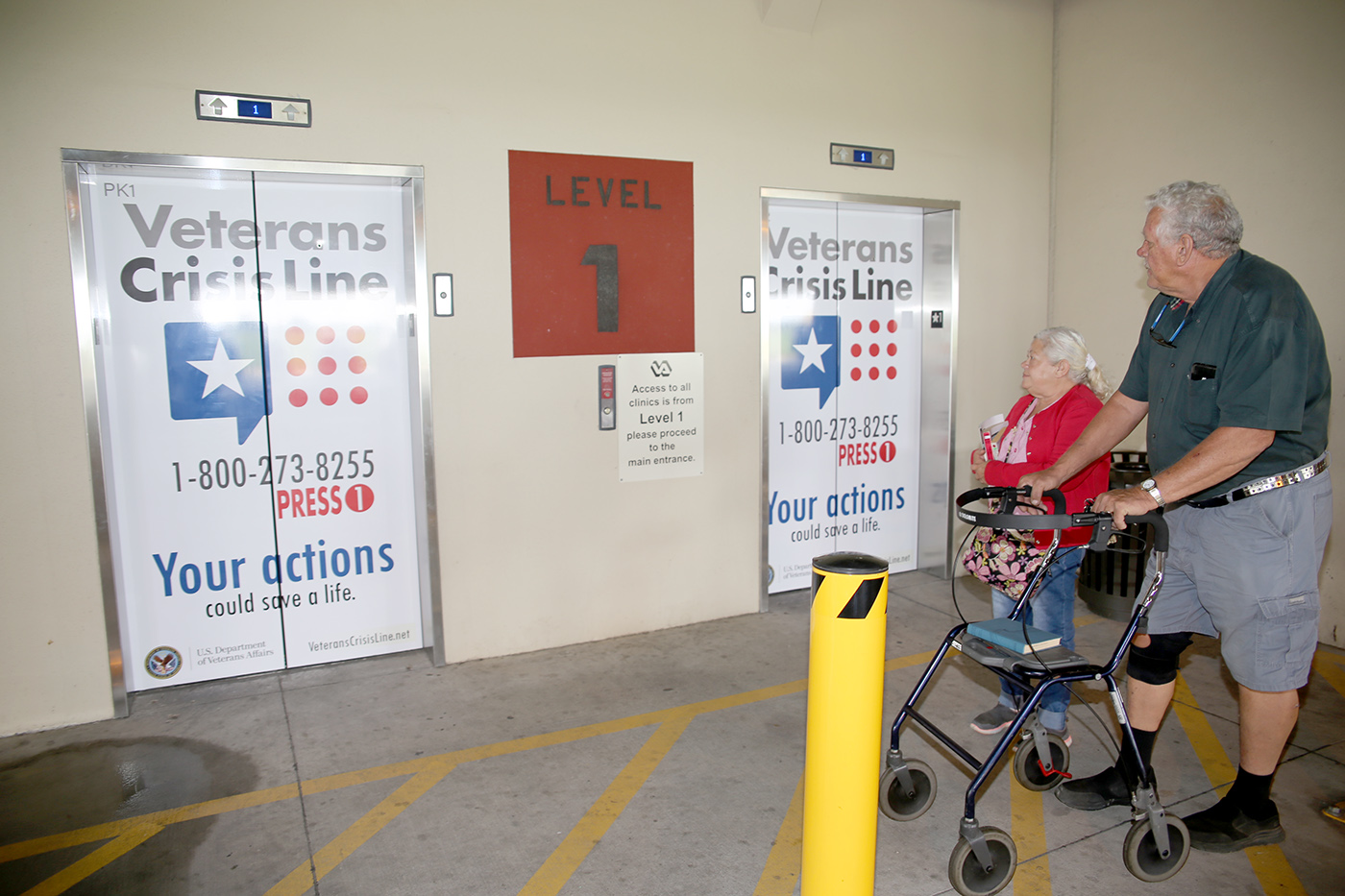Navy Veteran Richard W. Noyes and his wife Mary notice the newly decorated elevator doors with the Veterans Crisis Line logo and number as they make their way back to their vehicle after visiting the VA Health Care Center at Harlingen, Texas, on September 11, 2018.