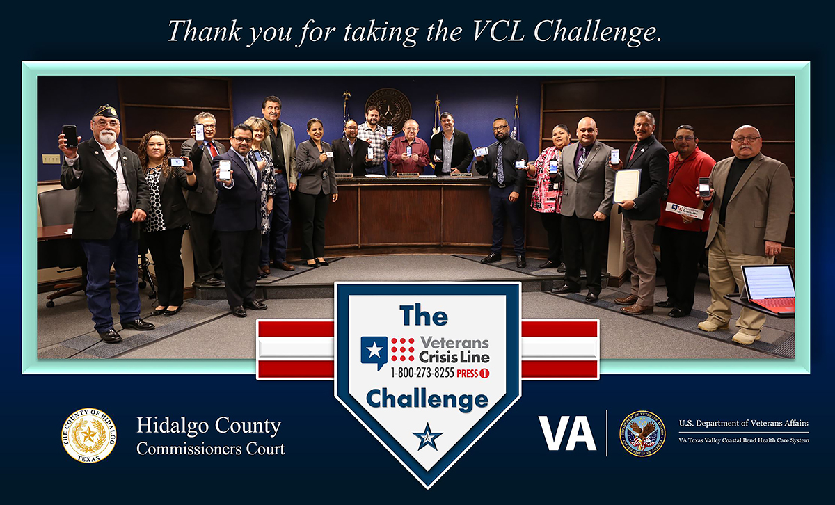 Members of VA Texas Valley Coastal Bend Health Care System (VCB), the Hidalgo County Community Service Agency and the Hidalgo County Commissioners Court pose for a group photo as a sign of solidarity in the effort to prevent suicides among service members and Veterans by displaying their phone screens as proof that they have completed the Veterans Crisis Line Challenge on November 20, 2018, at the Hidalgo County Commissioners courtroom in Edinburg, Texas. (VA photo by Reynaldo Leal used for the creation of this VA photo illustration by Luis H. Loza Gutierrez) The Veterans Crisis Line Challenge also known as the VCL Challenge consists of a person adding the Veterans Crisis Line logo and number (1-800-273-8255, Press 1) to their phone contacts list, then posting a photo on social media of yourself showing the number on your phone.