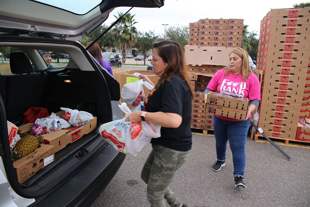 Food Bank of the Rio Grande Valley (RGV) employees place boxes and bags of produce into the back of vehicle driven by a Veteran during the Free Produce Distribution Drive-thru held December 12, 2018, at the parking lot of the VA outpatient clinic at McAllen, Texas. This year's event marks the second time an event of this kind has taken place. Overall, a total of 273 families consisting of 607 adults and 226 children (from military families) received more than 10,100 pounds of nutritional fruits and vegetables. (U.S. Department of Veterans Affairs photo by Luis H. Loza Gutierrez)