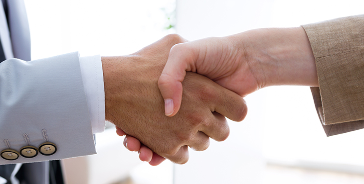 Image shows two people shaking hands