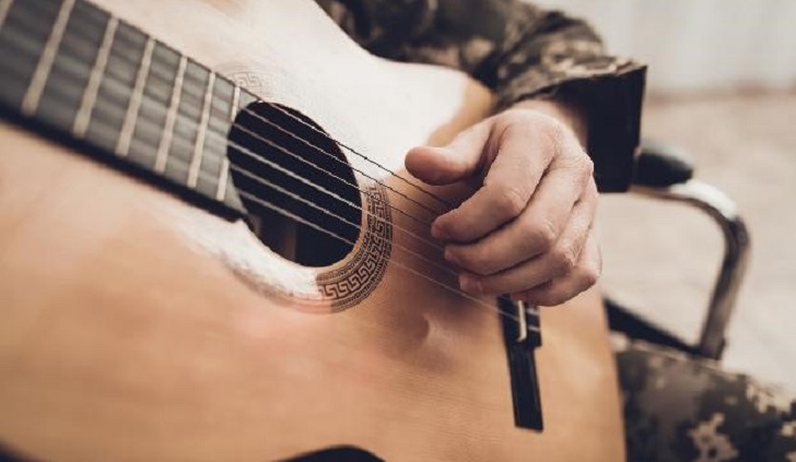IMAGE: Hand strumming a guitar
