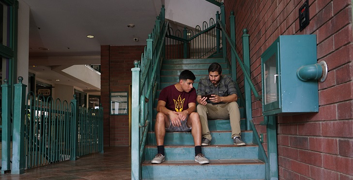 IMAGE: Two men sitting on the stairs.