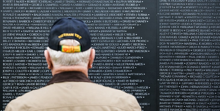A veteran stands in front of the Wall that Heals