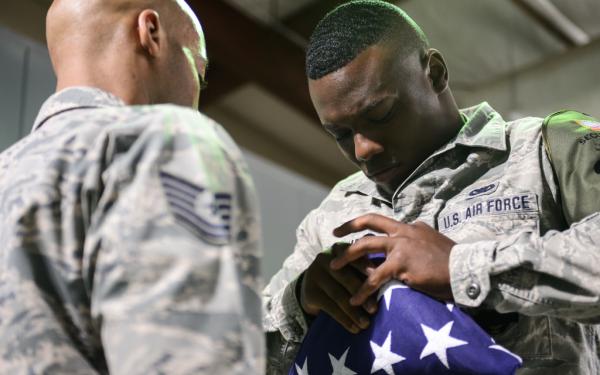 An Air Force airman folds an American flag
