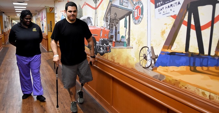 IMAGE: U.S. Army Veteran Charles Jones works with Tashenia Hunter, physical therapist, learning to walk with his new prosthetic leg. Jones is in the Amputation Specialty Program (ASP), an intense rehabilitation program requiring three hours of therapy a day.