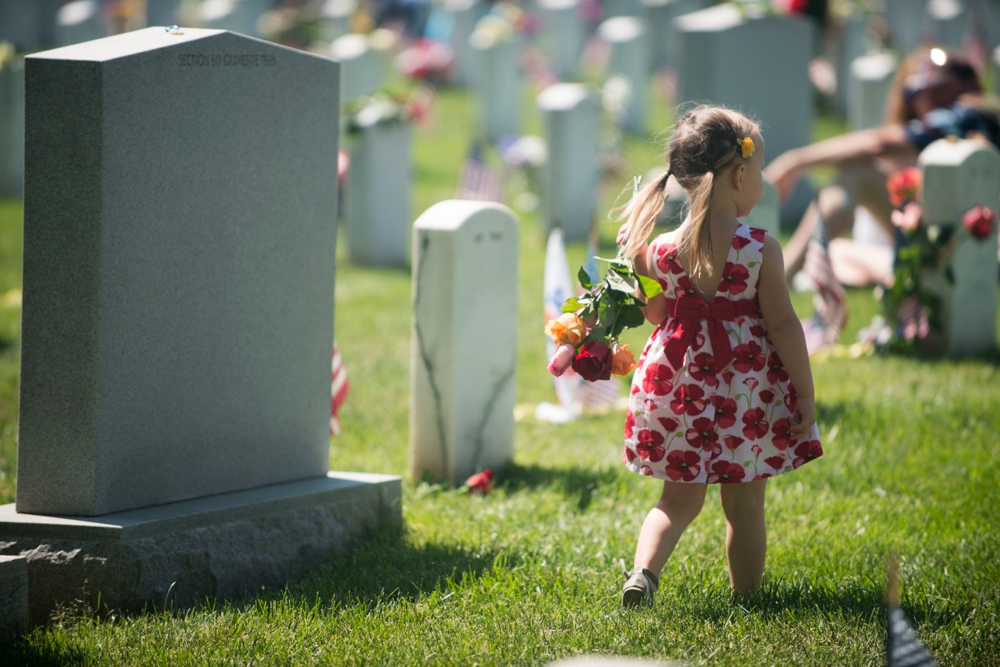 Image of child walking with flowers during Memorial Day