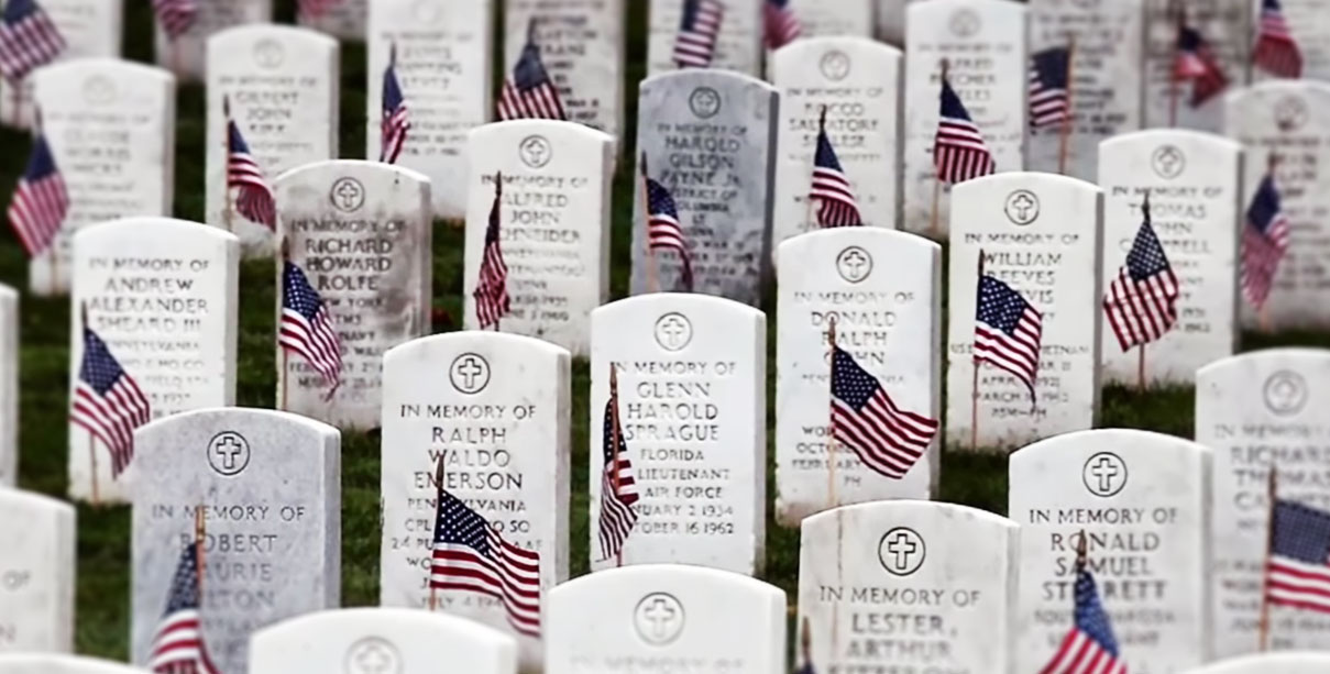 Picture of a graveyard with tombstones decorated with American flags