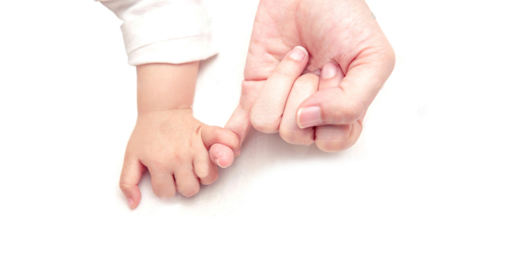 Image: baby hand holding an adult finger