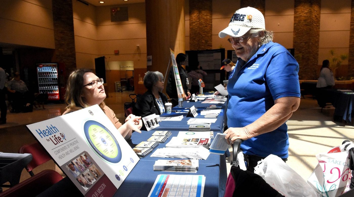 A women Veteran speaks with a VA employee at a Women's Health Week event.