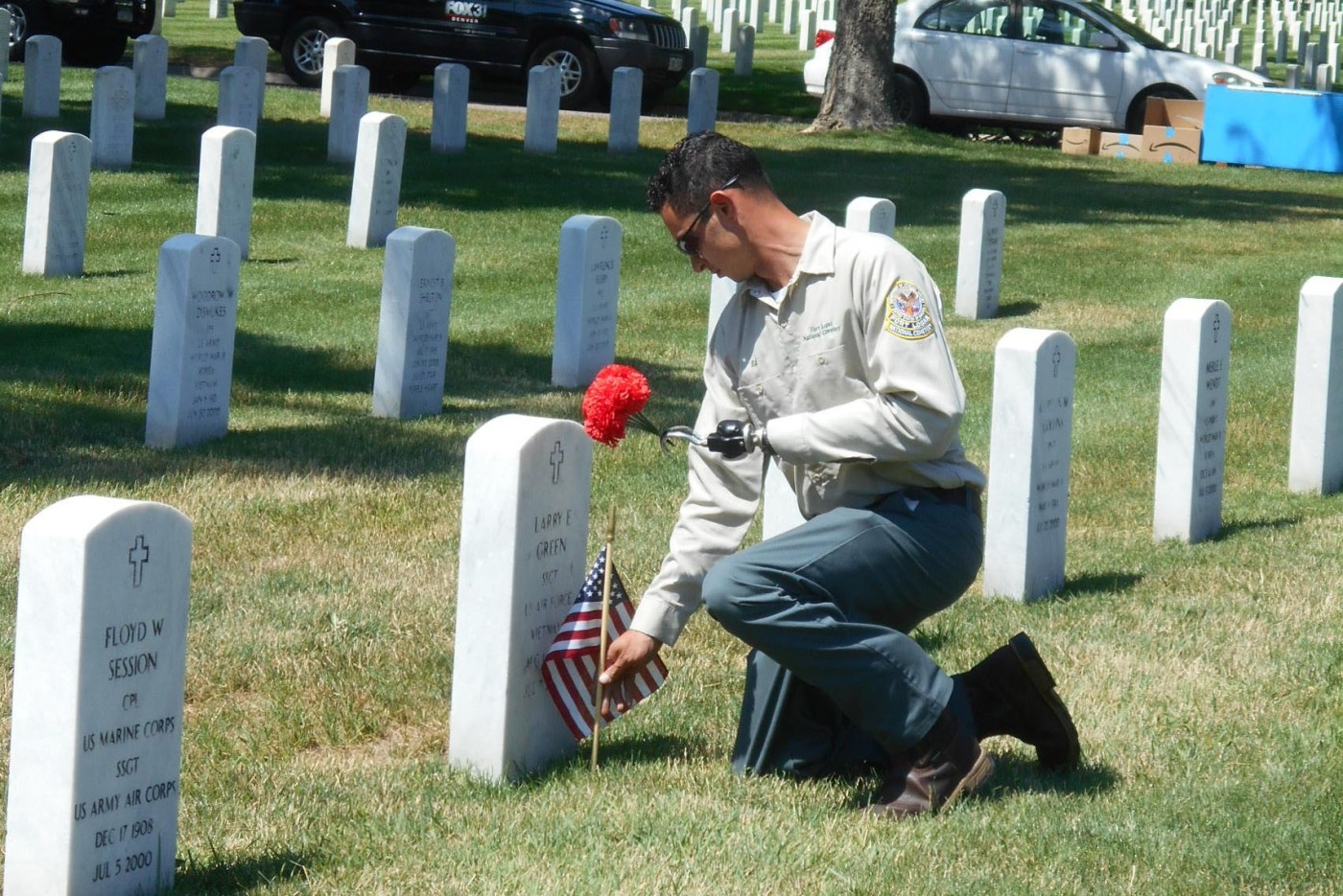 Lyons placing flags, flowers at grave.