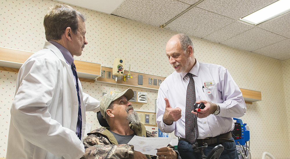 Two doctors and a Veteran patient in a wheelchair