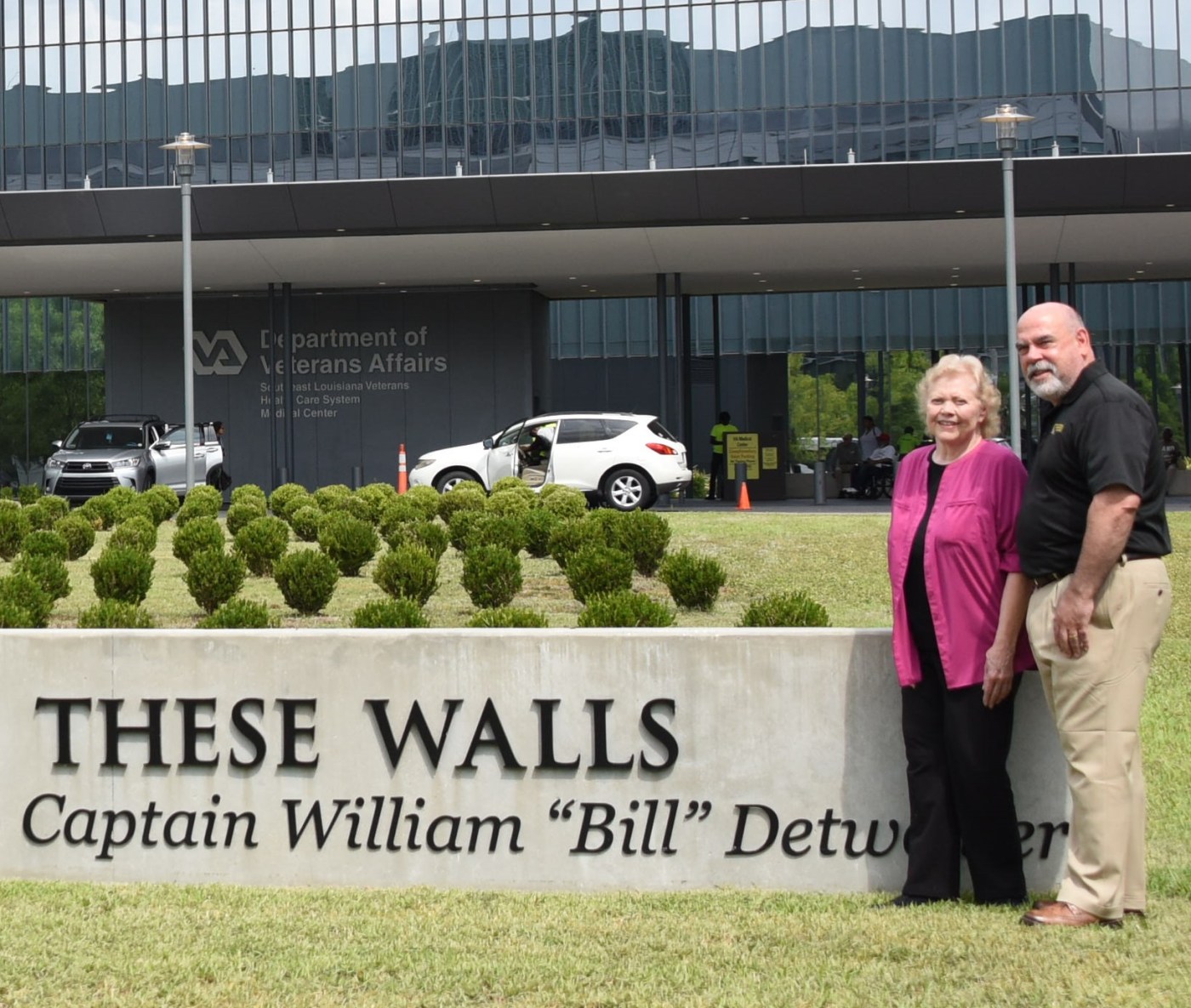 Mrs. Detweiler stands with VA New Orleans director in front of her late husband's quote now adorning the facade.